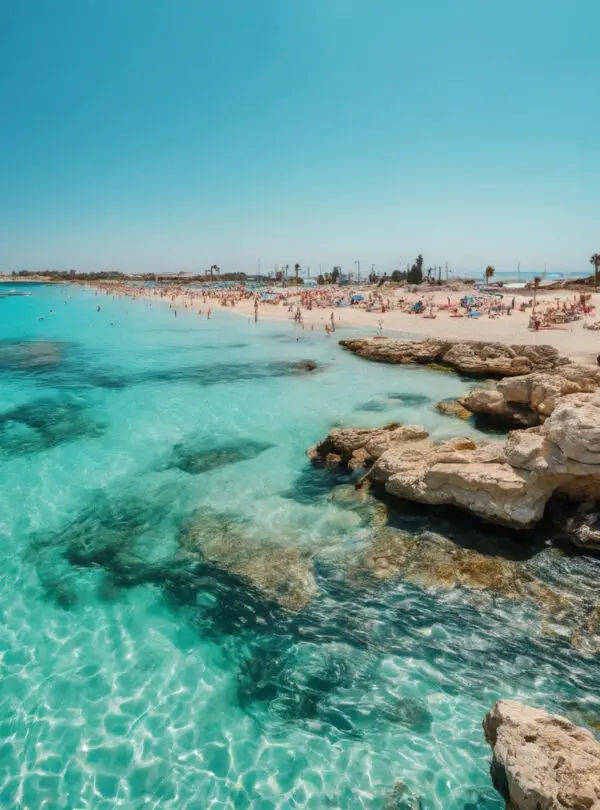 Beach photo of Ayia Napa, Cyprus with clear blue sky and crystal-clear turquoise water. Use vibrant, saturated colors
