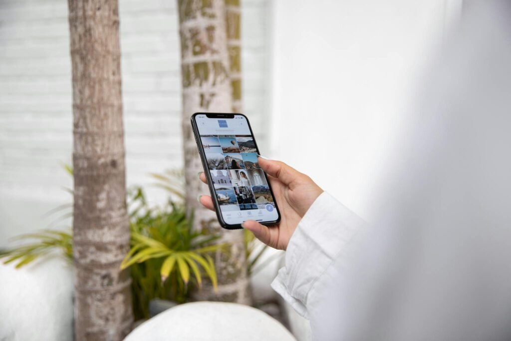 Special Offers A woman using a smartphone to browse social media while standing outdoors in a tropical setting.