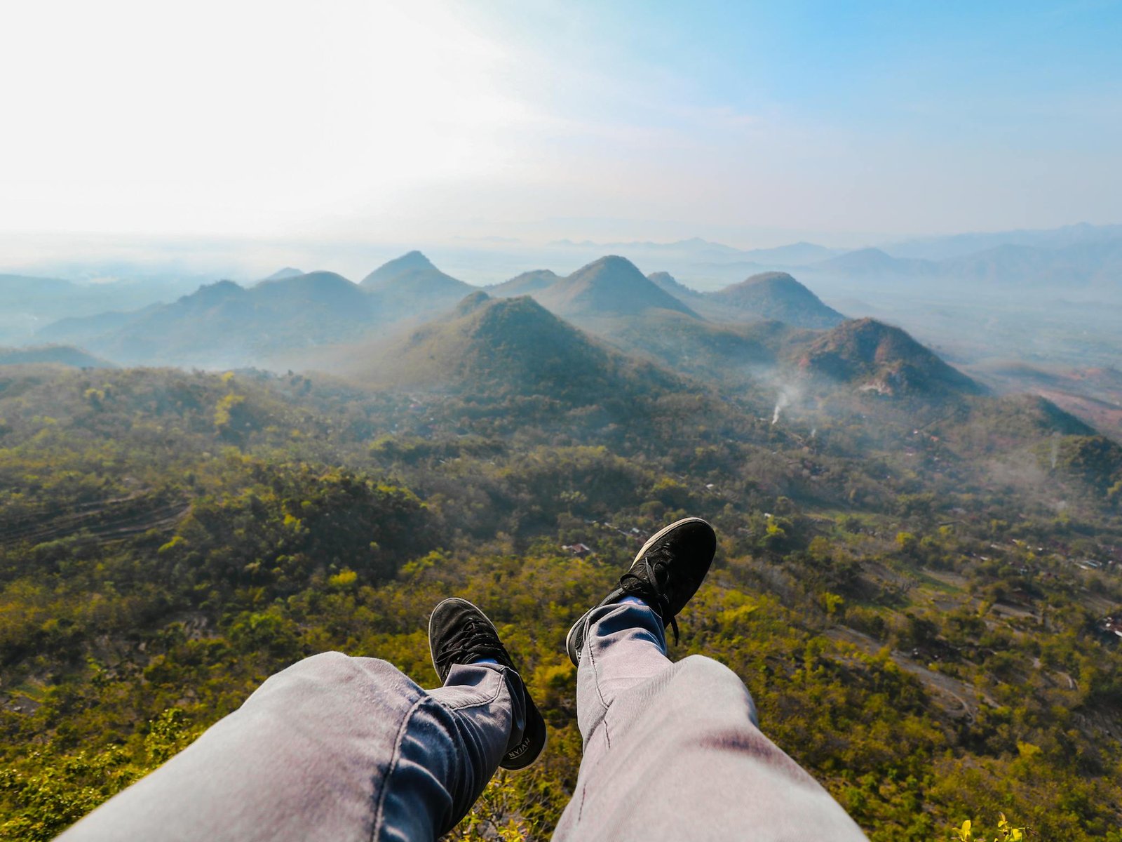 Special Offers Feet dangling over the stunning landscape of Wonogiri Hills during sunrise, capturing the essence of Indonesian nature.